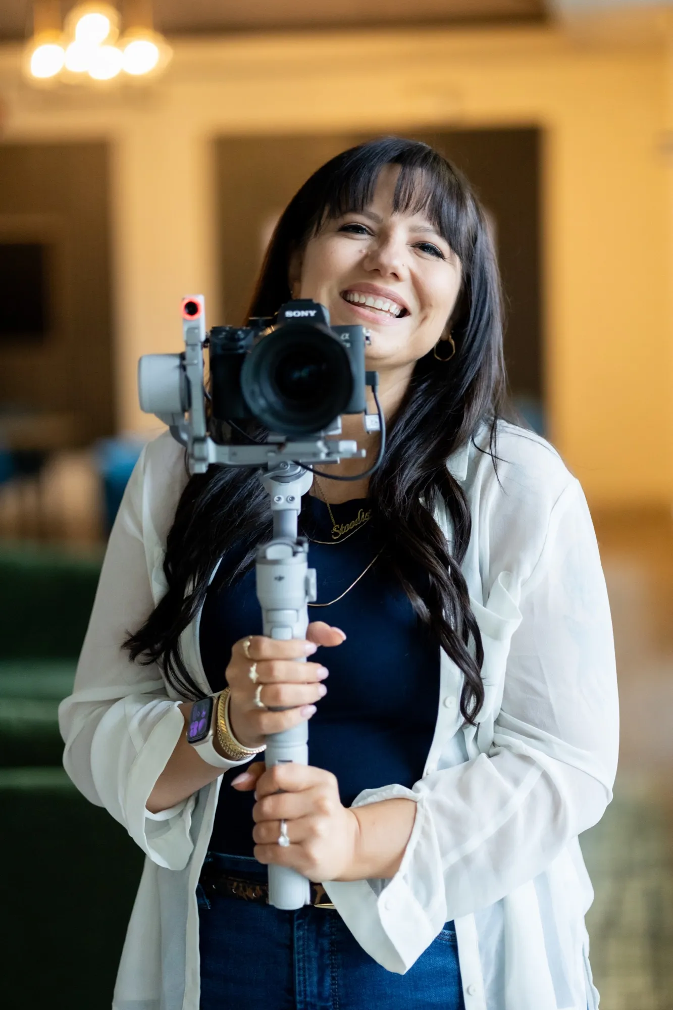 Brooke holding a camera on a gimbal, smiling