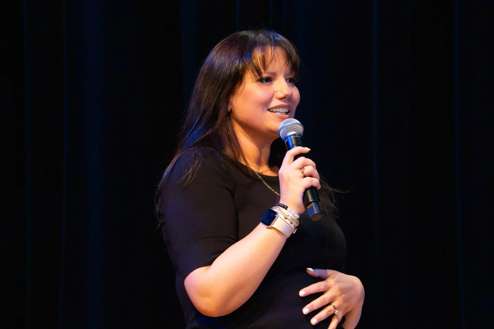 Brooke mid-laugh on stage, microphone at her mouth